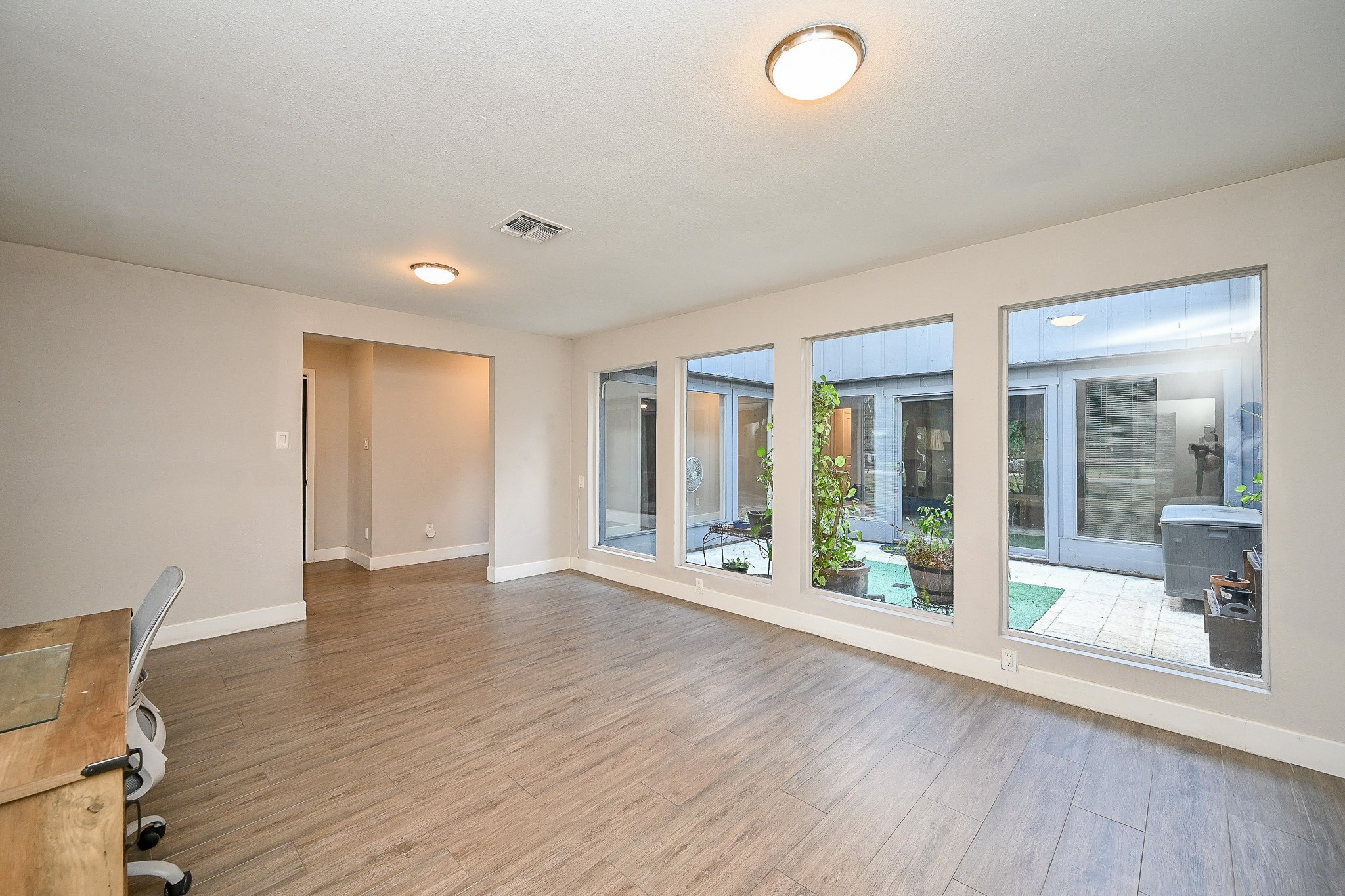 2406 Encreek Road Houston, TX 77068 - Photo 5 of 25 a view of an empty room with wooden floor and a window