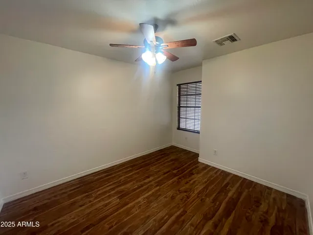 a view of a room with wooden floor and fan