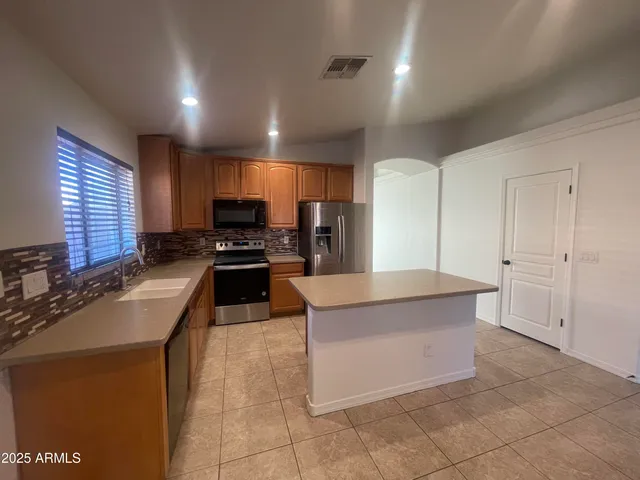 a kitchen with stainless steel appliances granite countertop a stove a sink and a refrigerator