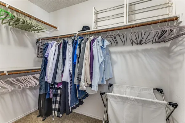 a view of walk in closet with clothes and shoes