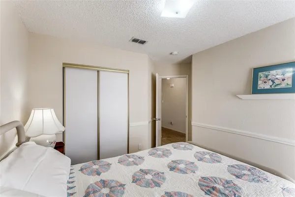 a bedroom with a bed and a painting on the wall