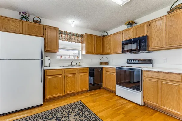 a kitchen with stainless steel appliances granite countertop a refrigerator sink stove and microwave