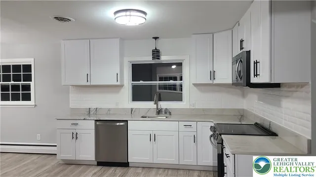 a kitchen with stainless steel appliances a sink stove and cabinets