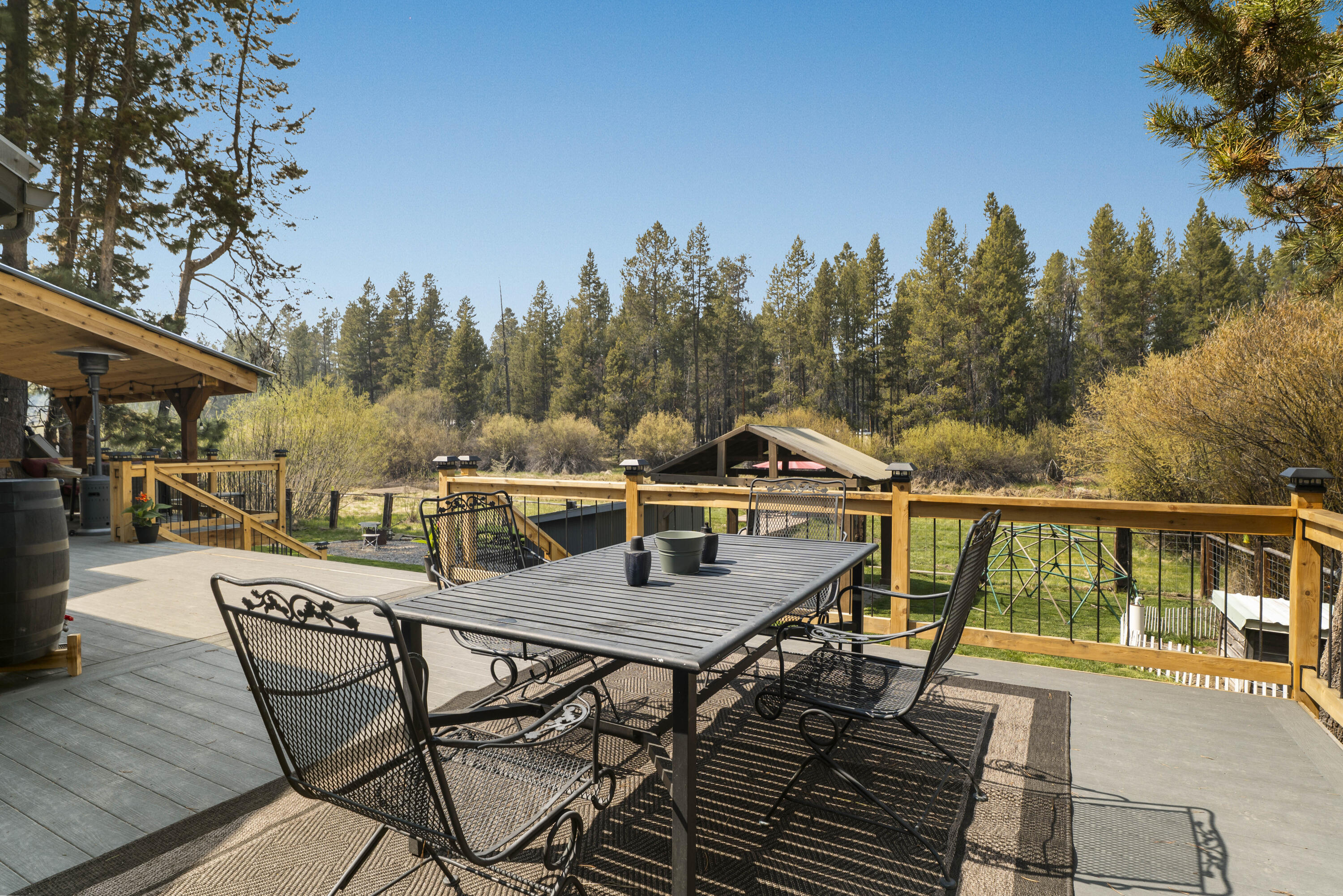 17062 Milky Way Bend, OR 97707 - Photo 22 of 39 Wrought-iron dining set on the deck under towering ponderosa pines