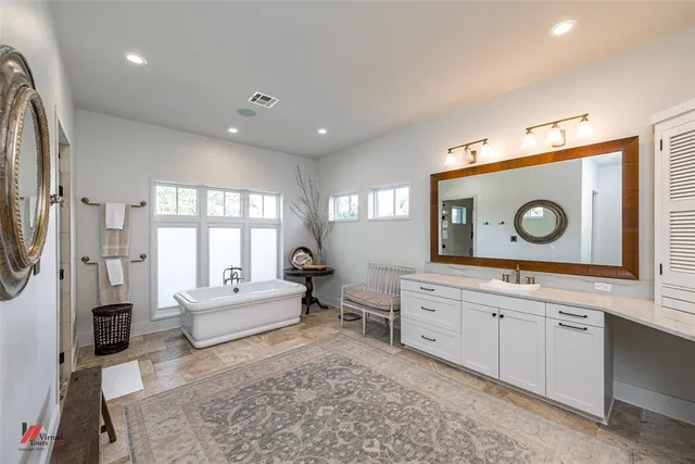 a spacious bedroom with a bed and a dresser