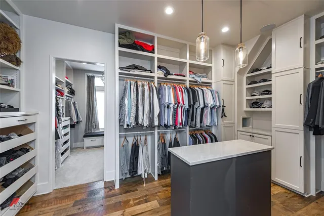 a view of walk in closet with clothes and shoes