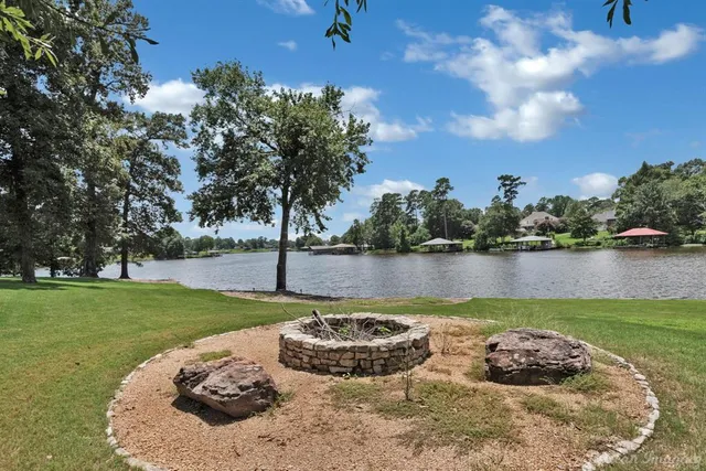 a view of a lake with a swimming pool and a yard