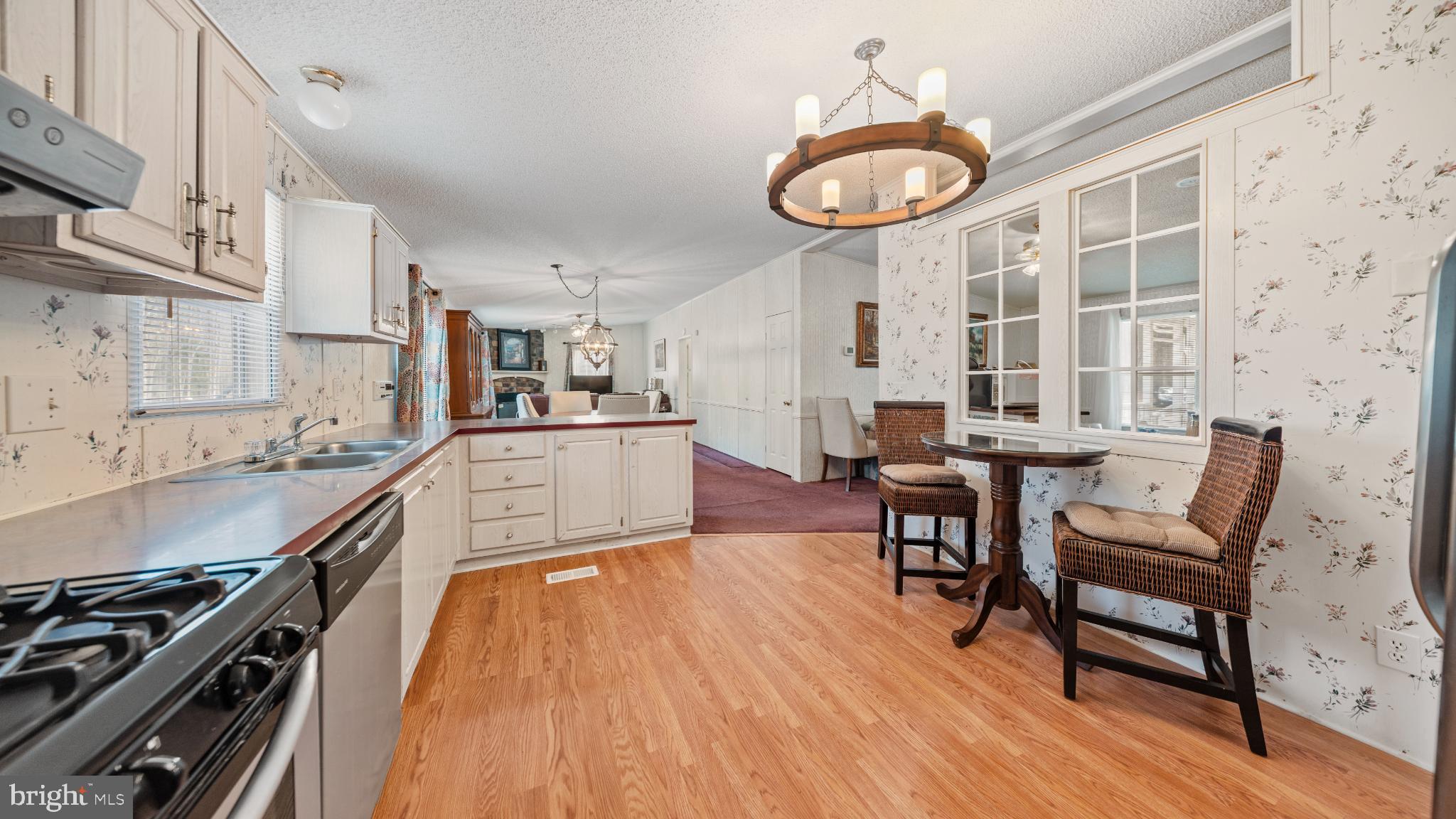 32520 Seatick Road Eden, MD 21822 - Photo 11 of 31 a kitchen with stainless steel appliances a stove a sink a dining table and chairs with wooden floor