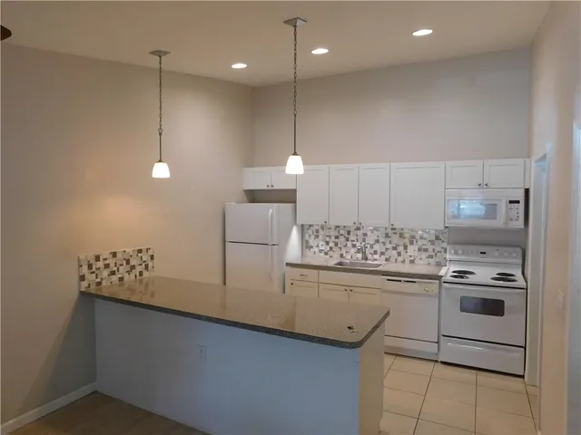 a kitchen with kitchen island a stove a sink and a refrigerator