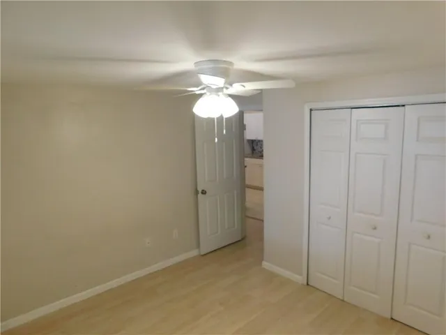 wooden floor in closet and a chandelier fan in a room
