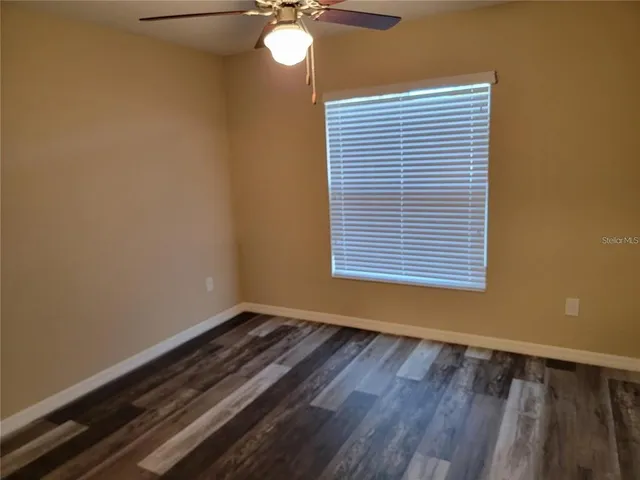 a view of a room with wooden floor and a window