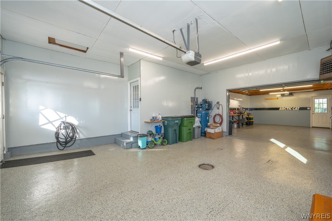 6463 Ward Road Sanborn, NY 14132 - Photo 37 of 49 An oversized garage features durable epoxy flooring and direct entry to an adjacent workshop space.