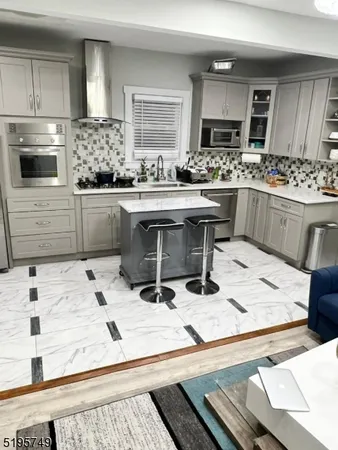 a kitchen with kitchen island granite countertop a sink and appliances