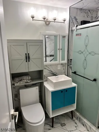 a bathroom with a granite countertop toilet sink and mirror