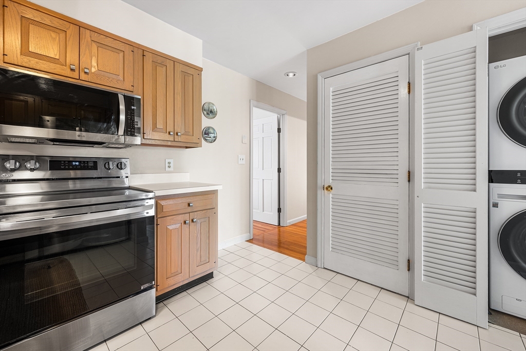 63 Garden Road, Unit C5 Wellesley, MA 02481 - Photo 10 of 30 a kitchen with stainless steel appliances a stove microwave and cabinets