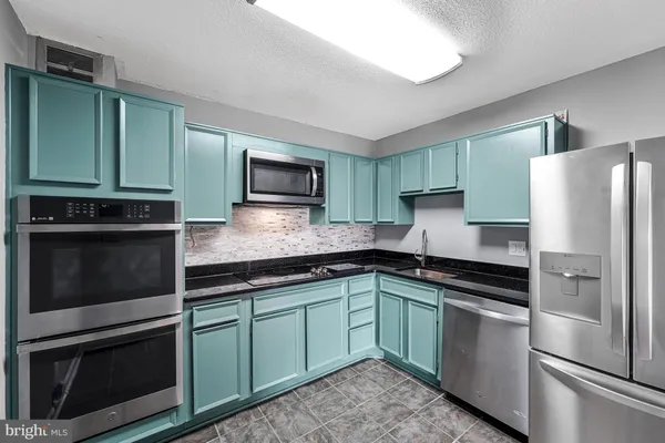 a kitchen with a refrigerator sink and microwave