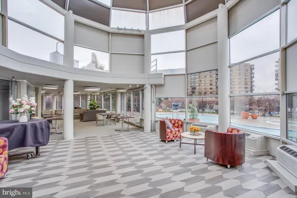 a dining room with furniture and a floor to ceiling window