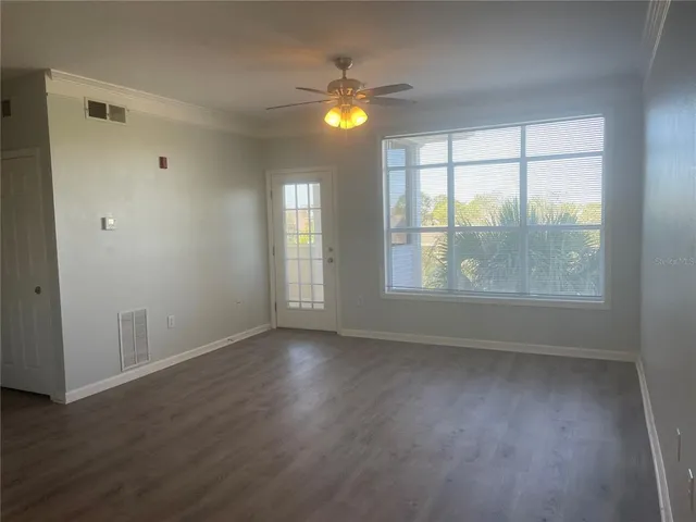 an empty room with wooden floor and windows