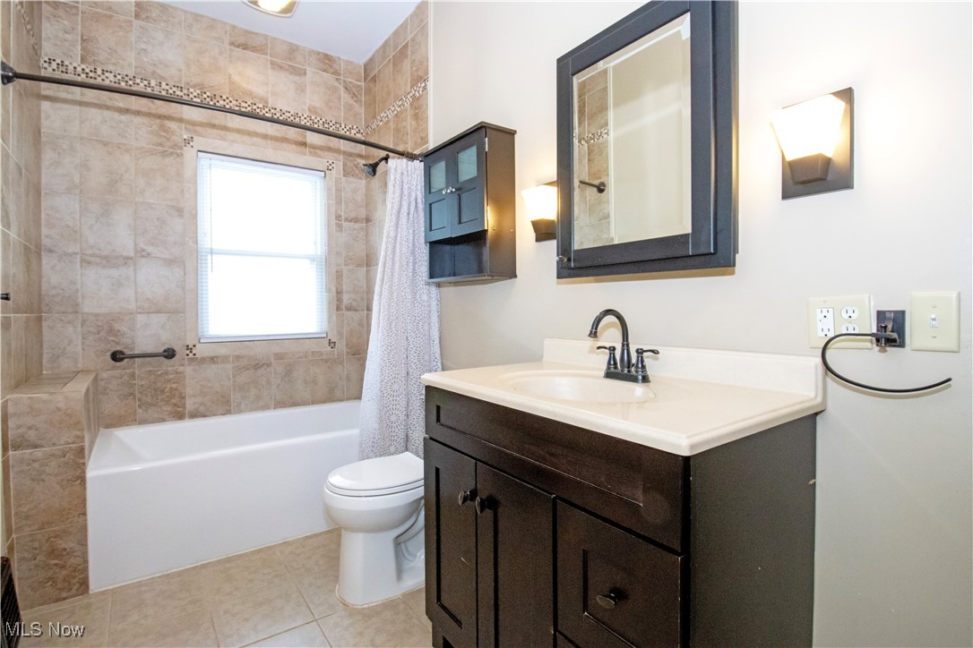 5699 Massillon Road Dalton, OH 44618 - Photo 4 of 24 Full bathroom with toilet, vanity, shower / bathtub combination with curtain, and tile patterned flooring
