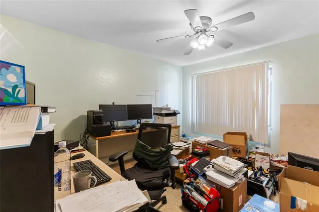 a view of a workspace with furniture and a window