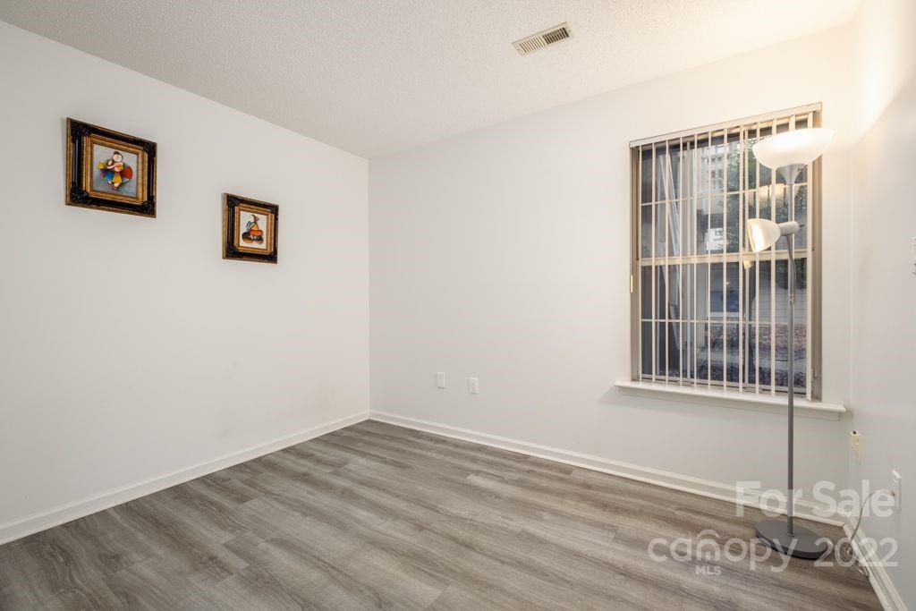 5003 Sharon Road, Unit C Charlotte, NC 28210 - Photo 13 of 27 a view of an empty room with wooden floor and a window