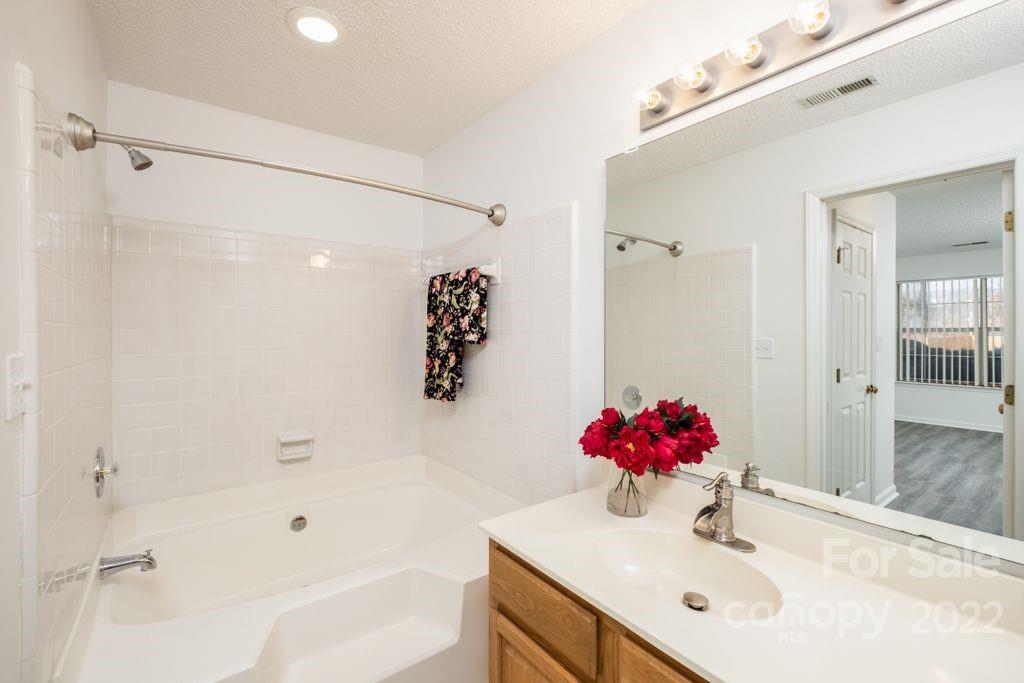 5003 Sharon Road, Unit C Charlotte, NC 28210 - Photo 21 of 27 a bathroom with a bathtub sink vanity and shower