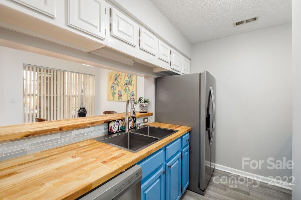 5003 Sharon Road, Unit C Charlotte, NC 28210 - Photo 10 of 27 a kitchen with stainless steel appliances granite countertop a sink a refrigerator and a stove