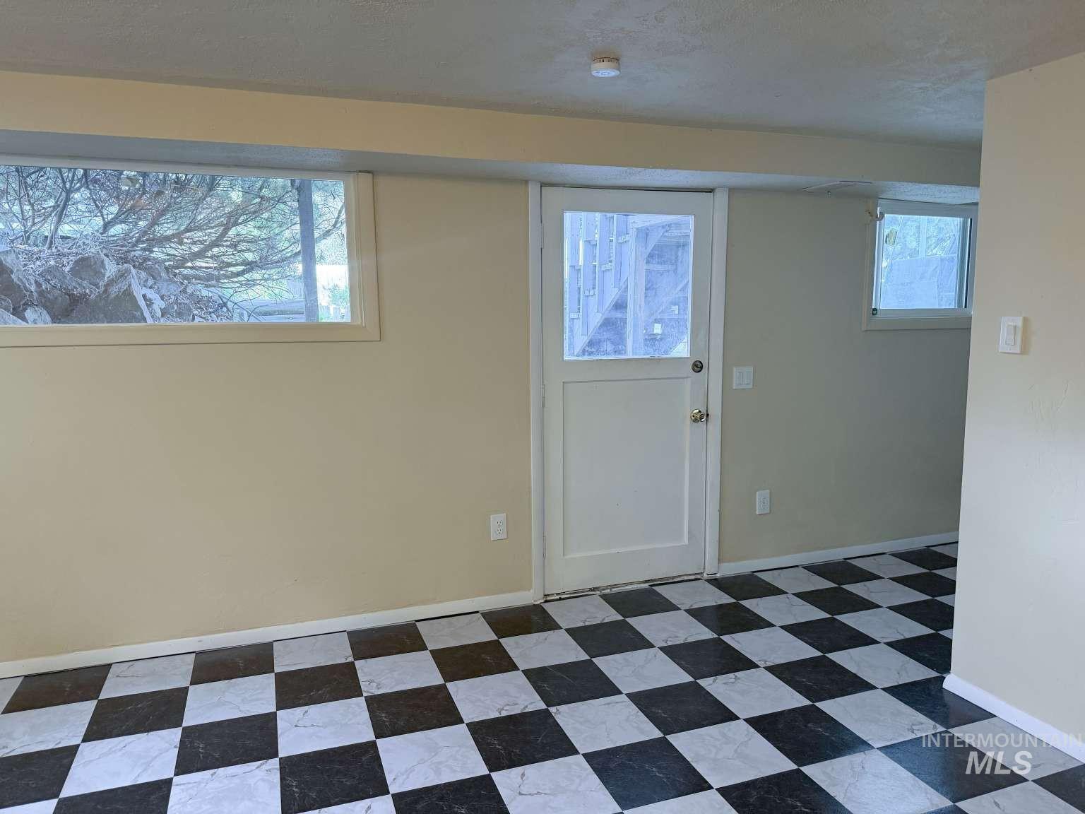 1158 South Powerline Road Nampa, ID 83686 - Photo 43 of 46 Interior space featuring checkerboard pattern flooring, multiple windows, and a glass-paneled door