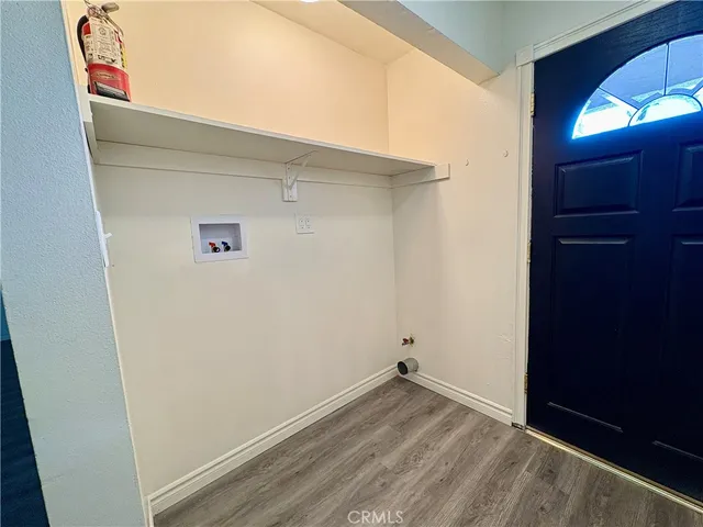 a kitchen with a sink a wooden floor and white cabinets