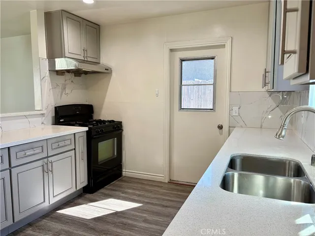 a kitchen with stainless steel appliances granite countertop a white cabinets and wooden floor