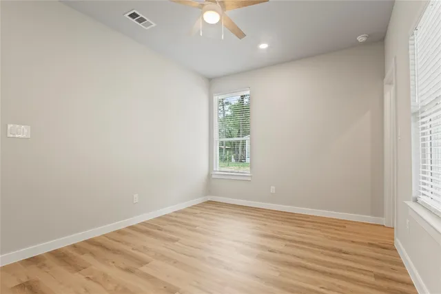 wooden floor in an empty room with a ceiling fan