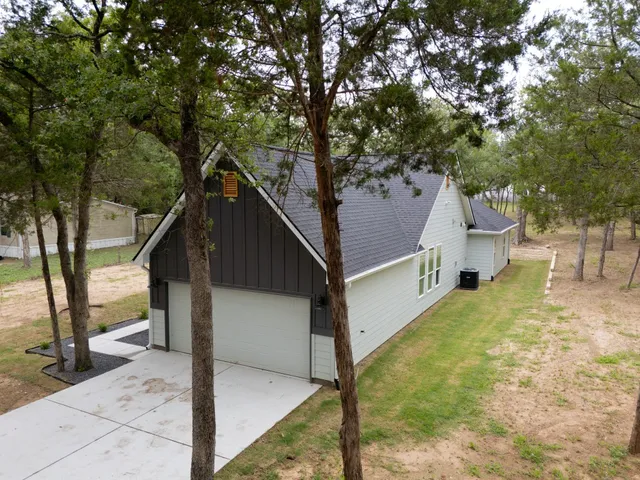 a view of a house with a tree and wooden fence
