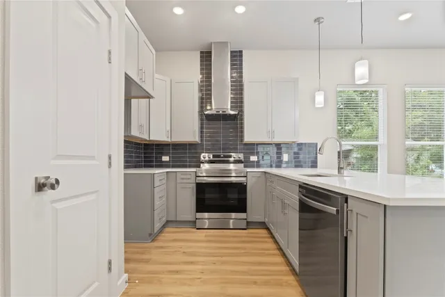 a kitchen with stainless steel appliances granite countertop a table chairs and white cabinets