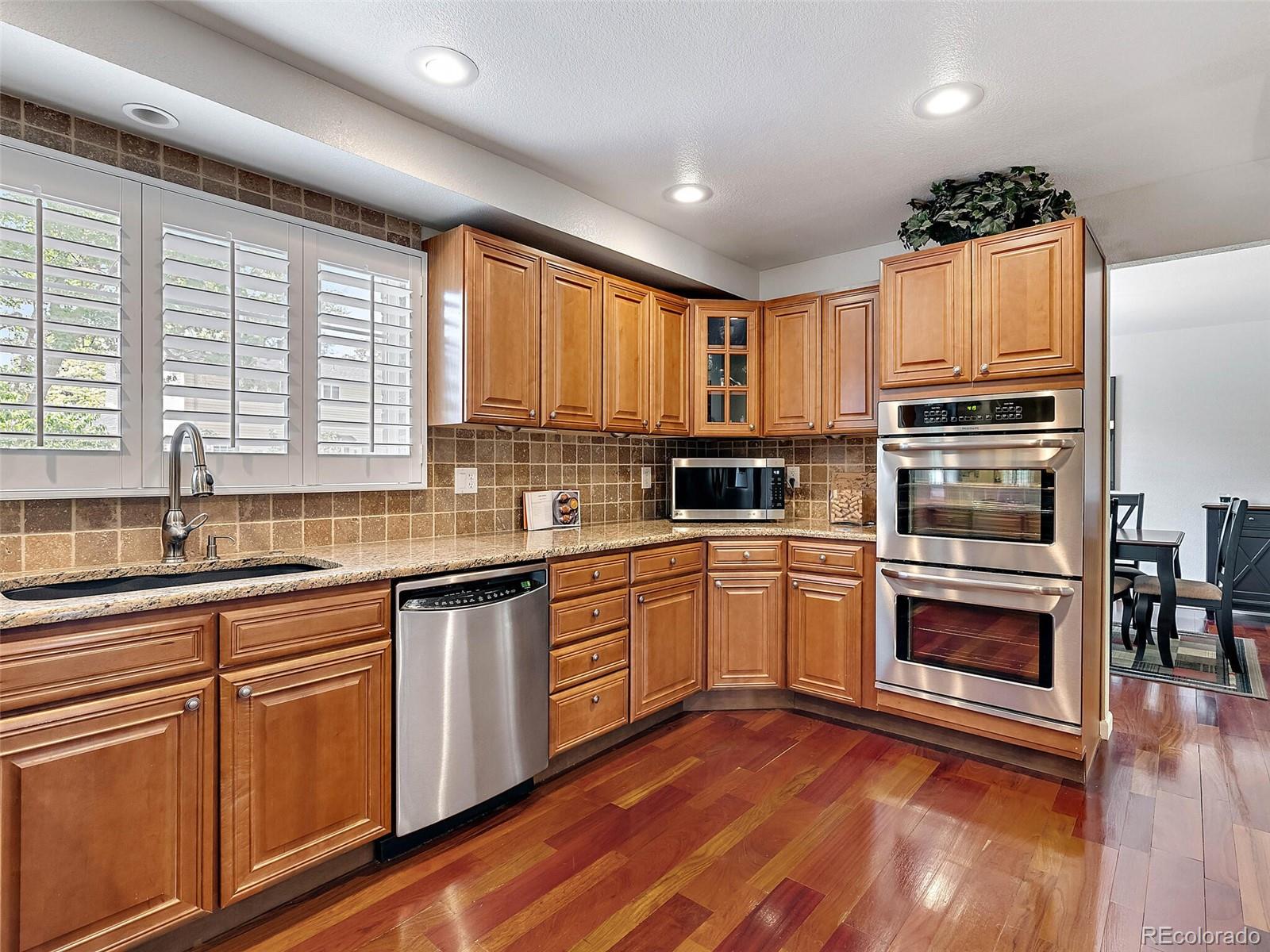 a kitchen with granite countertop stainless steel appliances a stove sink and microwave