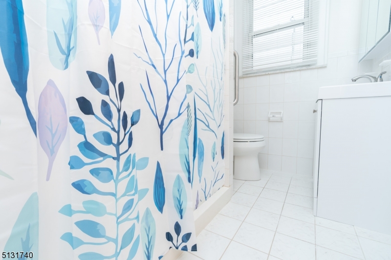 208 Tuscan Road, Unit 1 Maplewood, NJ 07040 - Photo 14 of 15 a bathroom with a sink and mirror with toilet