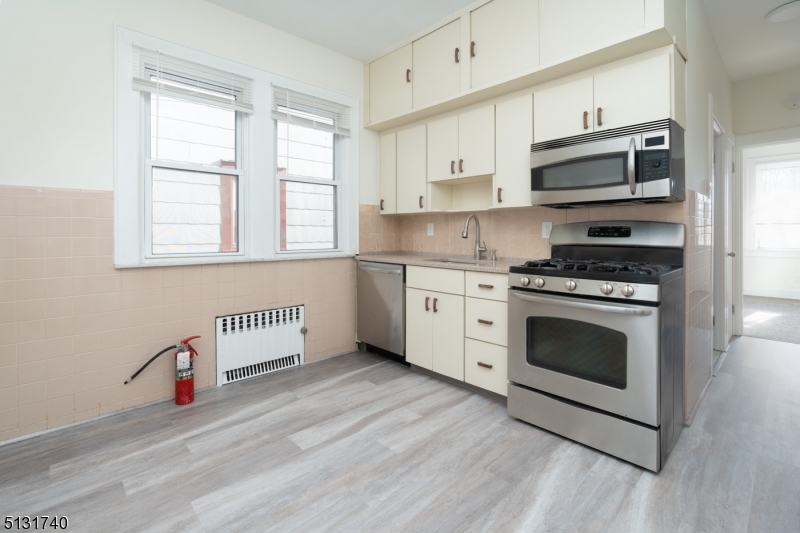 208 Tuscan Road, Unit 1 Maplewood, NJ 07040 - Photo 8 of 15 a kitchen with stainless steel appliances a stove a sink and a microwave