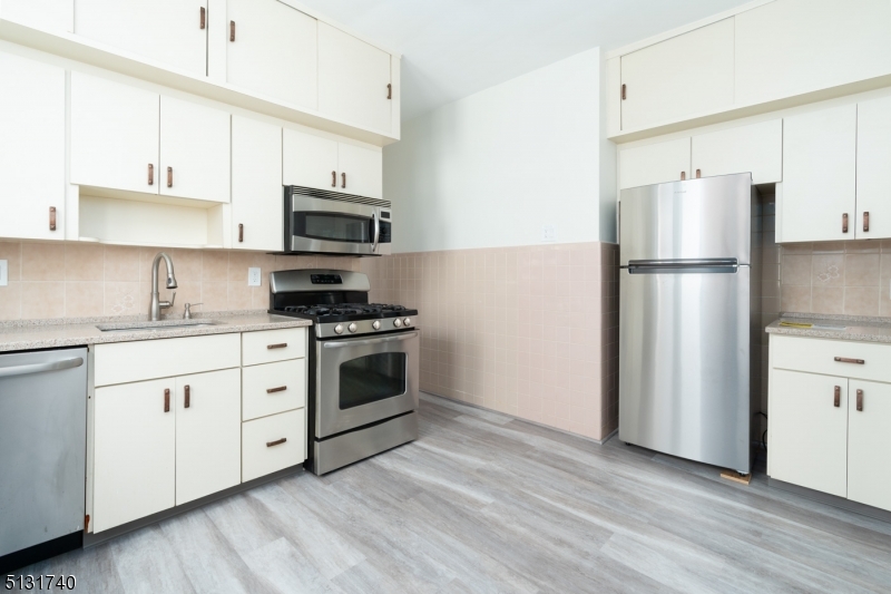 208 Tuscan Road, Unit 1 Maplewood, NJ 07040 - Photo 9 of 15 a kitchen with stainless steel appliances white cabinets and a refrigerator
