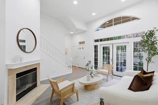a living room with furniture a fireplace and a floor to ceiling window