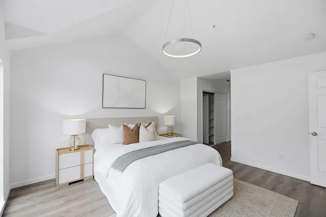 a bedroom with a bed and wooden floor