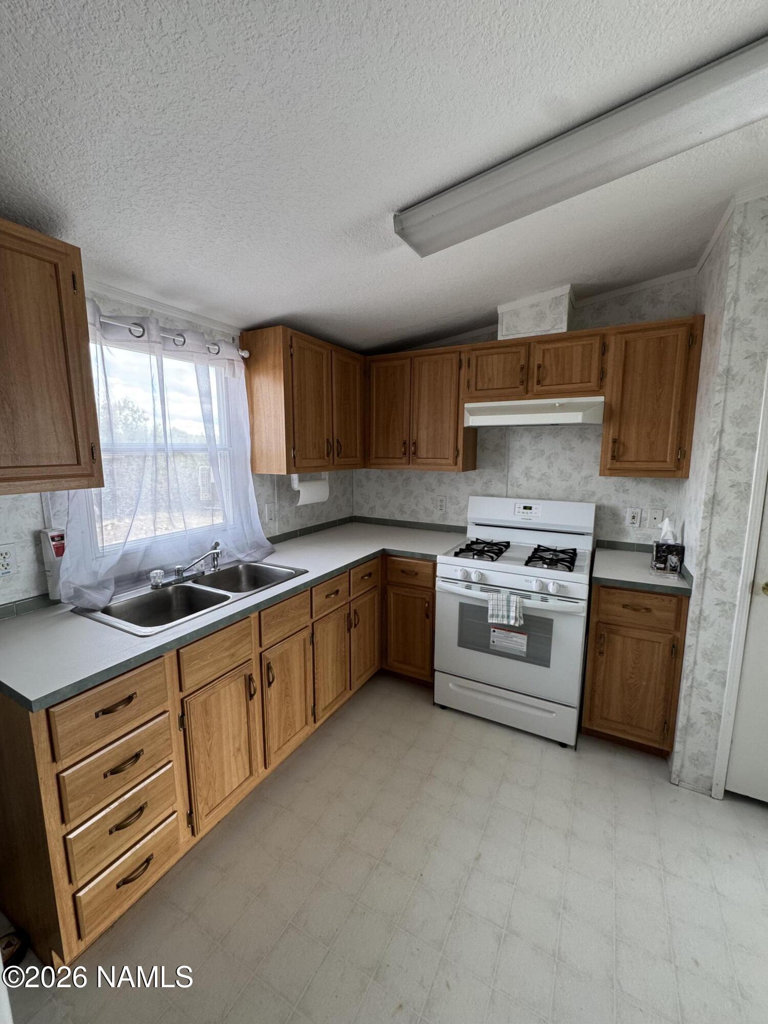 768 Mountain Cat Road Williams, AZ 86046 - Photo 11 of 37 a kitchen with stainless steel appliances granite countertop a stove sink and cabinets