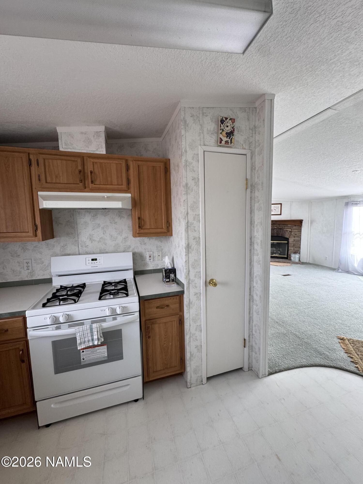 768 Mountain Cat Road Williams, AZ 86046 - Photo 12 of 37 a white stove top oven sitting inside of a kitchen