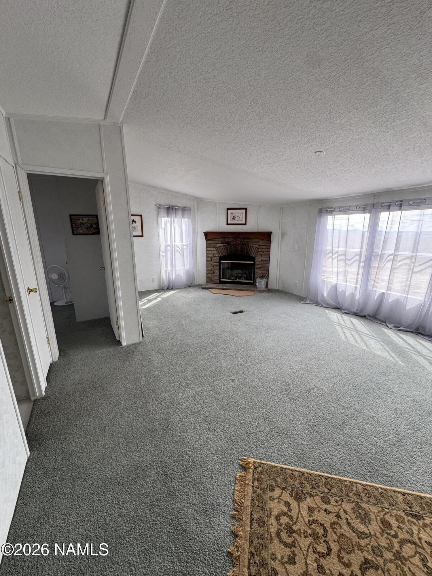 768 Mountain Cat Road Williams, AZ 86046 - Photo 13 of 37 a view of an empty room with a fireplace
