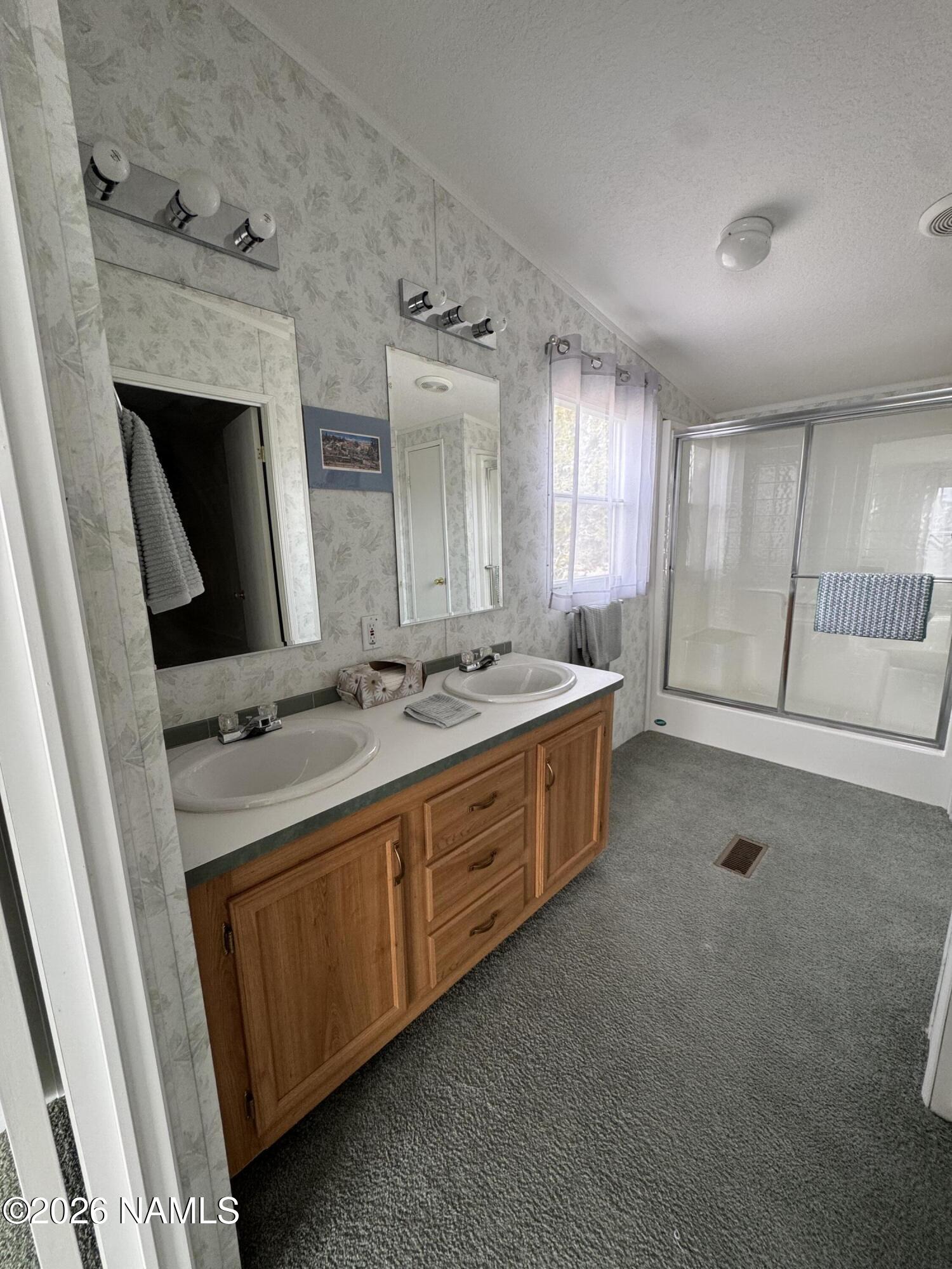 768 Mountain Cat Road Williams, AZ 86046 - Photo 19 of 37 a bathroom with a double vanity sink a mirror and a bathtub