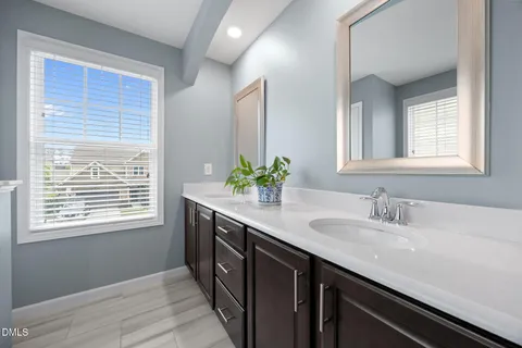 a bathroom with a granite countertop sink a mirror and a window
