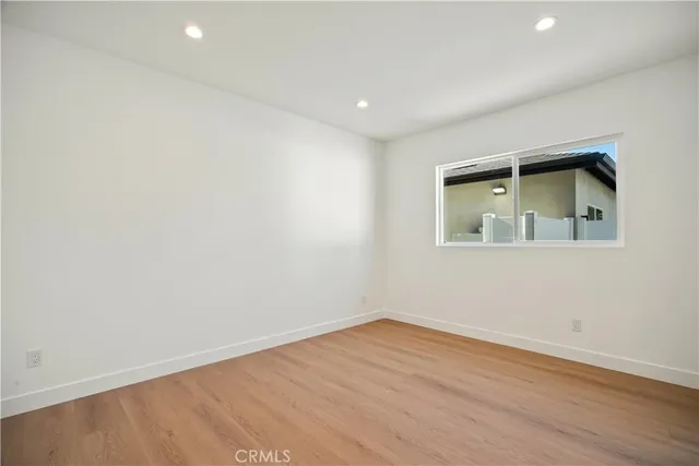 an empty room with wooden floor and a window