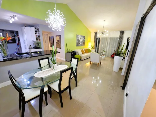 a kitchen with stainless steel appliances kitchen island granite countertop a table and chairs in it