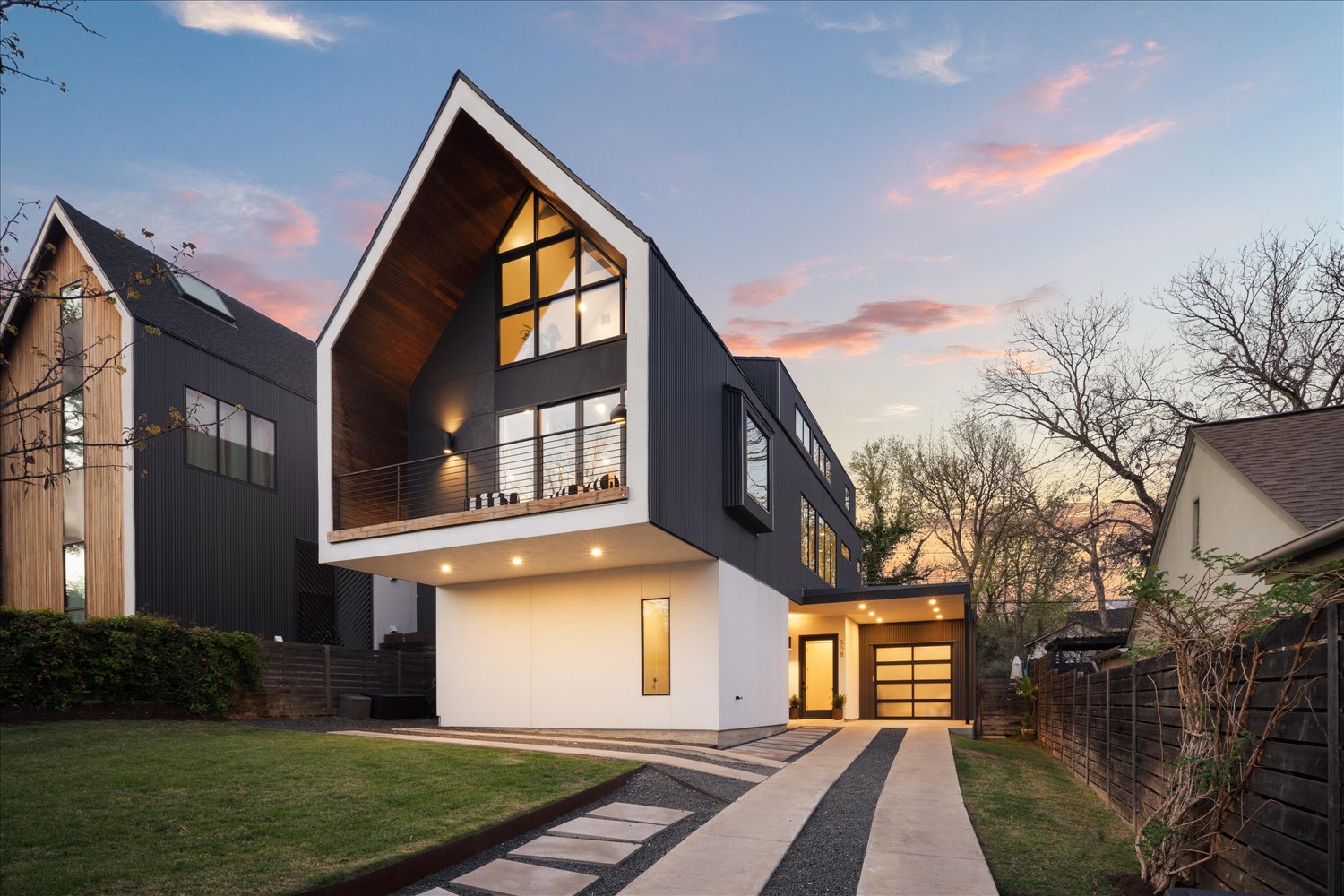 508 Leland Street Austin, TX 78704 - Photo 1 of 1 Front of house at dusk showing gated front yard, two carports, garage, and balcony off the primary suite.