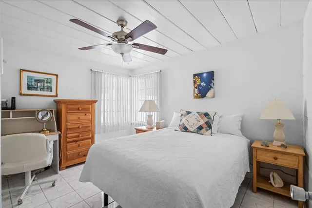 a bedroom with a bed a couch and a chandelier