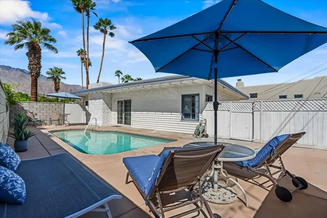a view of a patio with table and chairs under an umbrella