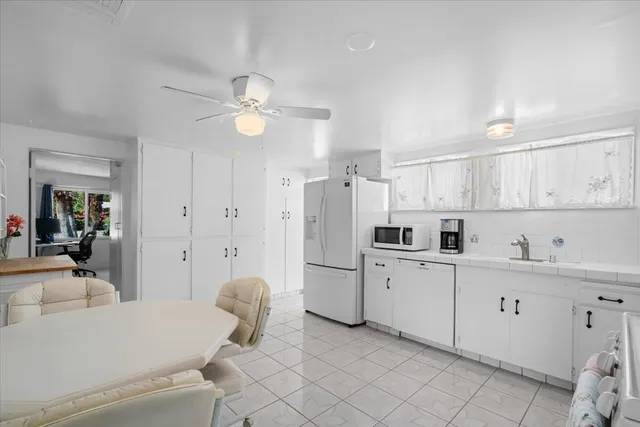 a kitchen with white cabinets and white appliances